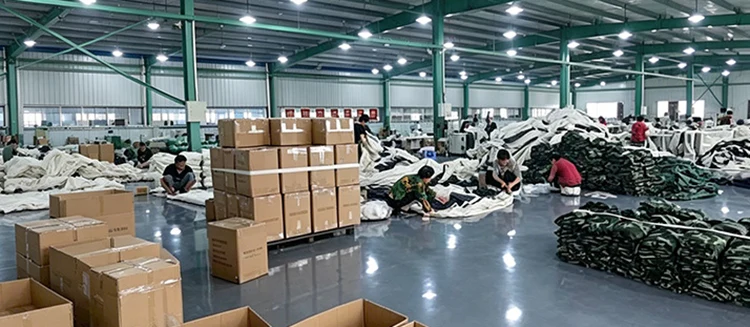 Finished car roof cargo bags sorting and packaging warehouse, workers packing wholesale rooftop storage packs into export cartons for bulk shipment